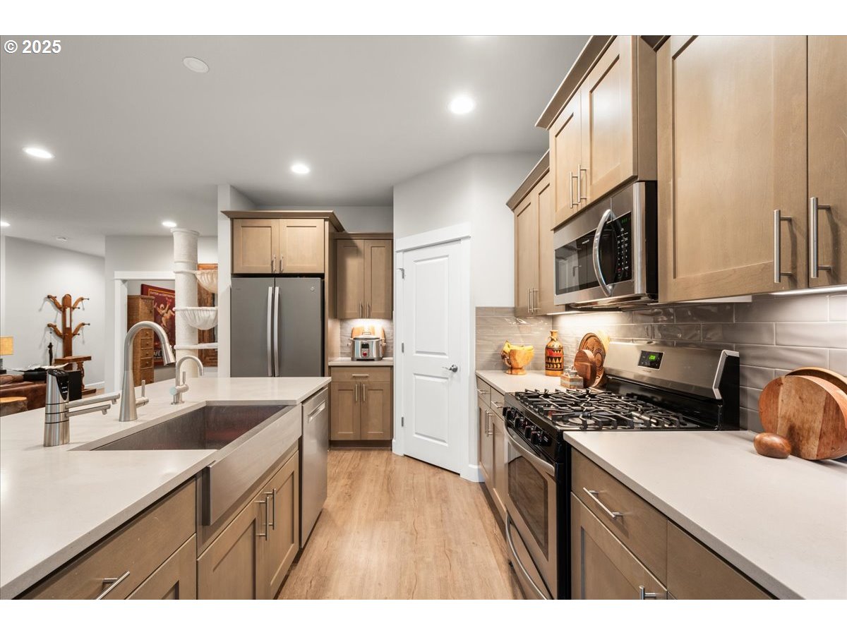 1715 Northeast 169th Street Ridgefield, WA 98642 - Photo 10 of 43 a kitchen with stainless steel appliances a sink a stove a refrigerator cabinets and a counter top space