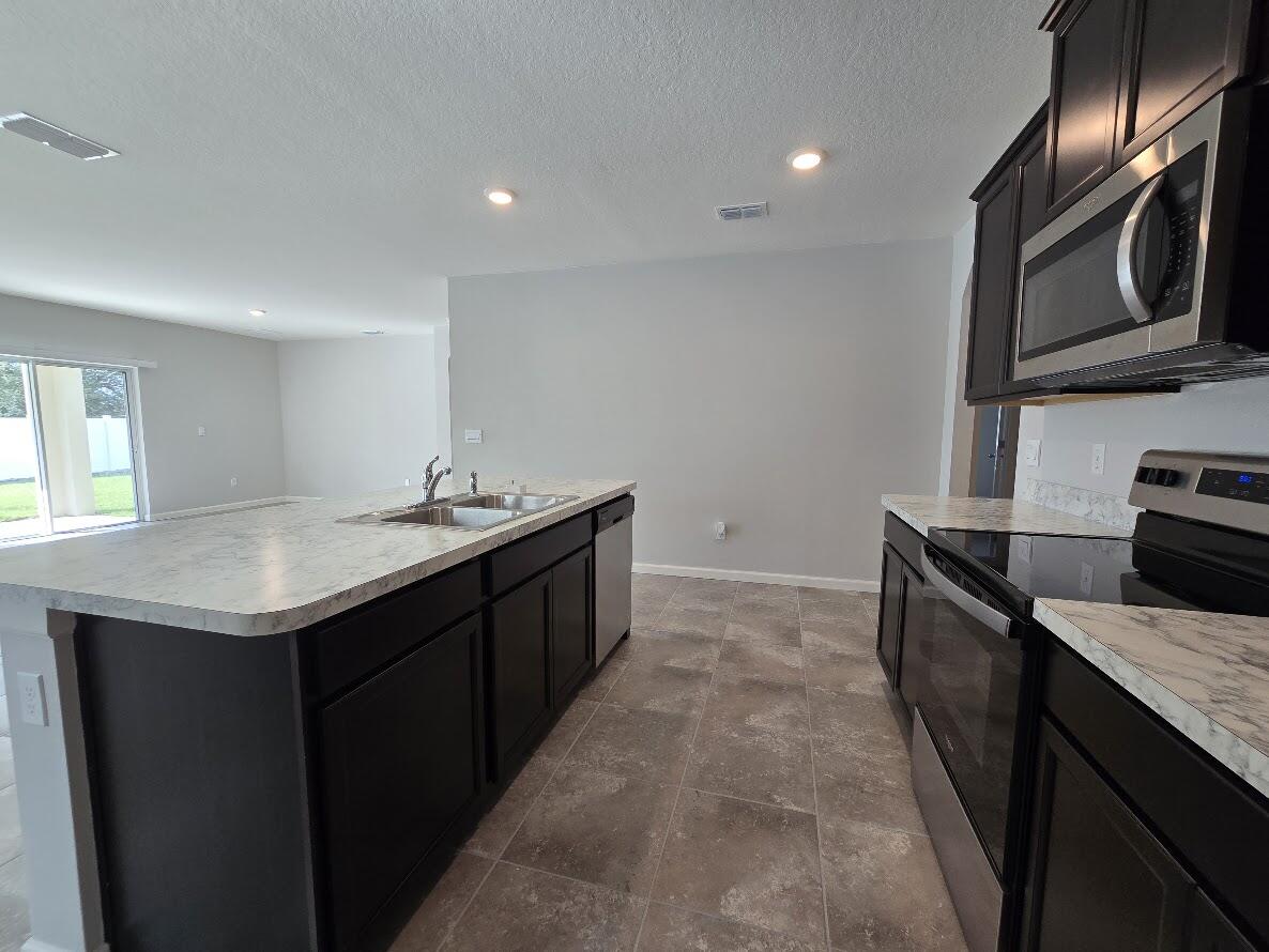 234 Southwest Becker Road Port St. Lucie, FL 34953 - Photo 11 of 44 a kitchen that has a sink and a stove in it