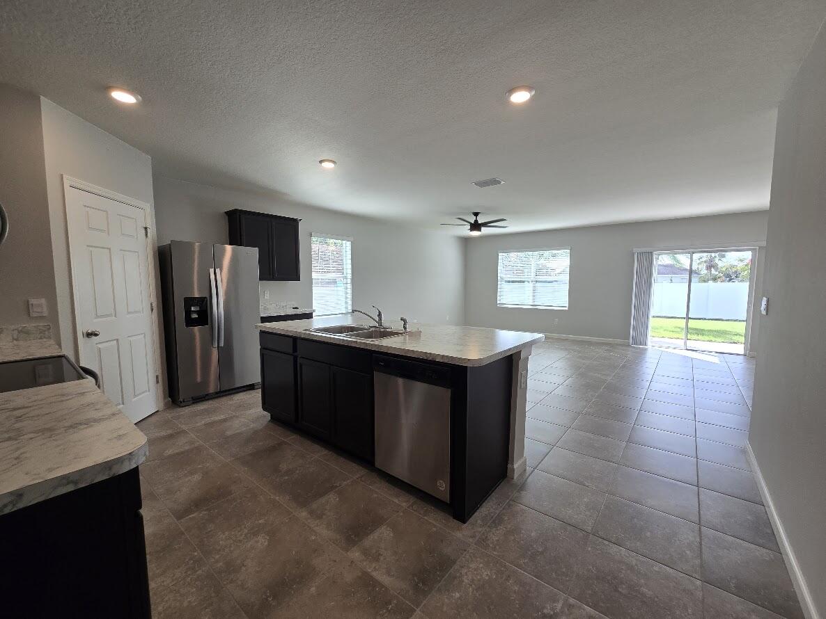234 Southwest Becker Road Port St. Lucie, FL 34953 - Photo 14 of 44 a kitchen with stainless steel appliances granite countertop a refrigerator and a sink