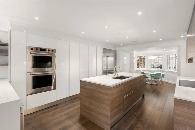 a backyard with table and chairs potted plants and large tree