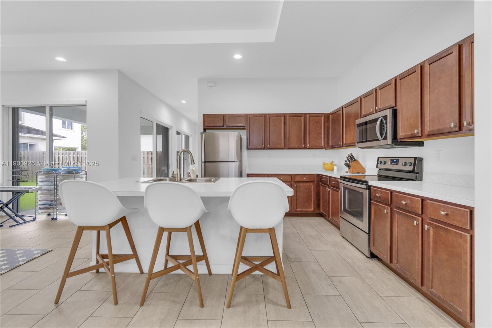 15288 Southwest 176th Terrace Miami, FL 33187 - Photo 19 of 68 a kitchen with stainless steel appliances granite countertop a table chairs sink and cabinets