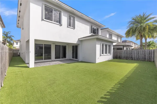 a view of a white house with a yard and plants