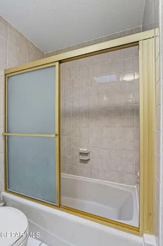 a bedroom with a bed and a flat tv screen on dresser