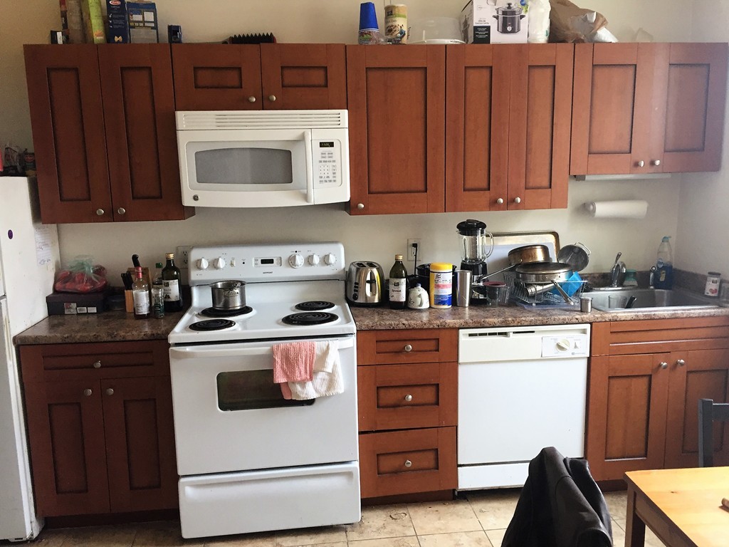 24 Ransom Road, Unit 9 Boston, MA 02135 - Photo 3 of 4 a kitchen with stainless steel appliances granite countertop a refrigerator stove and sink with wooden cabinets
