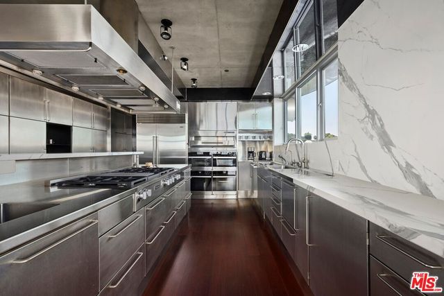 a kitchen with stainless steel appliances granite countertop a stove a sink and a refrigerator