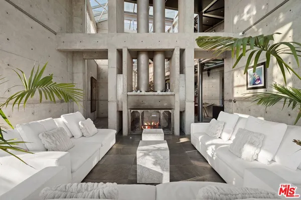 a living room with furniture a rug and a floor to ceiling window