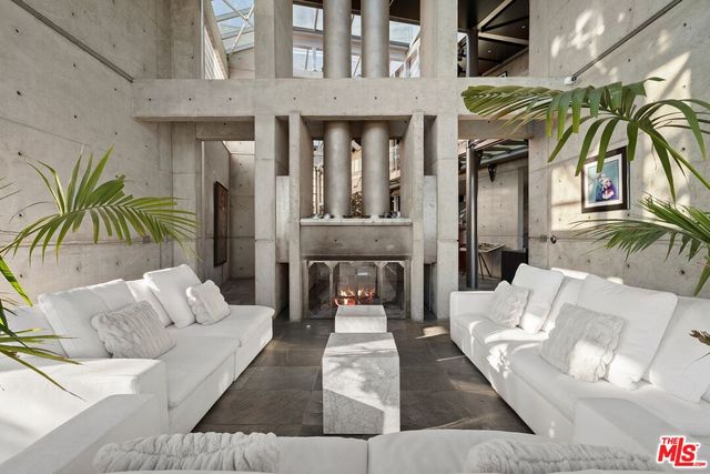 a living room with furniture a rug and a floor to ceiling window