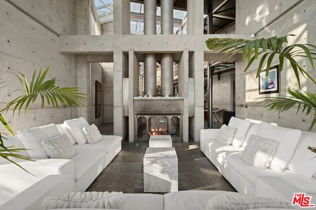 a living room with furniture a rug and a floor to ceiling window