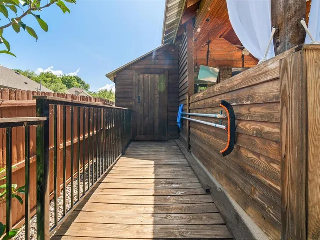 a view of a balcony with wooden floor and fence