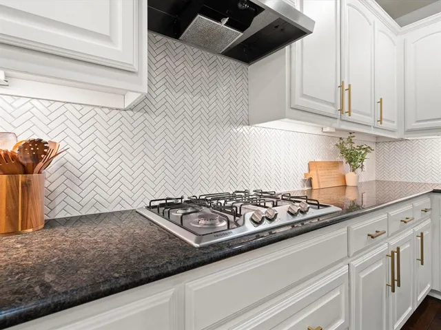 a kitchen with white cabinets and appliances