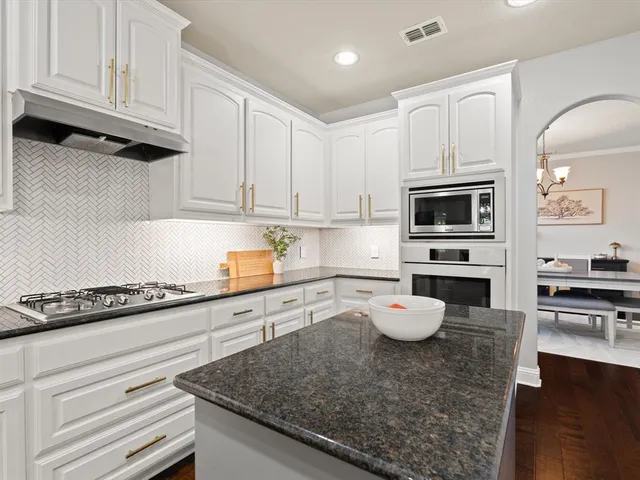a kitchen with granite countertop a sink stainless steel appliances and cabinets