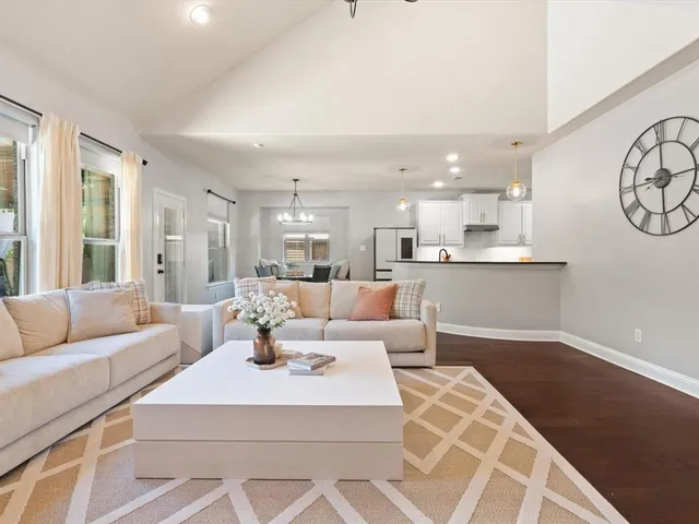 a living room with furniture and kitchen view
