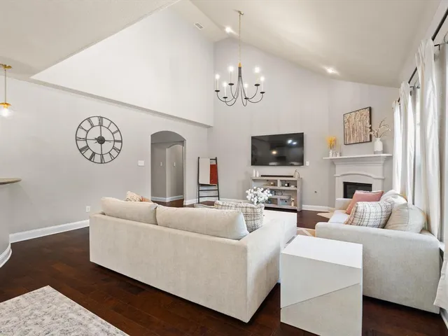a living room with furniture a fireplace and a flat screen tv