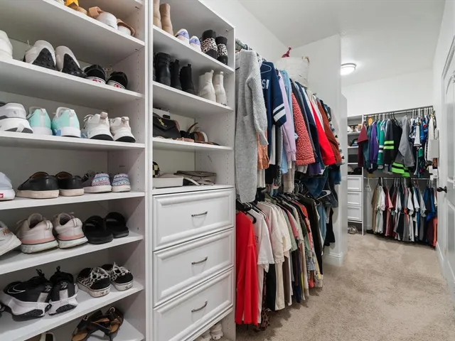 a view of walk in closet with clothes and shoes