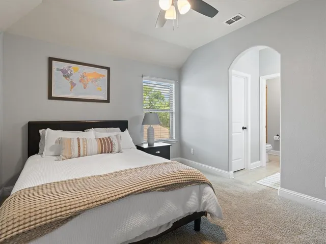 a bedroom with a large bed and a chandelier