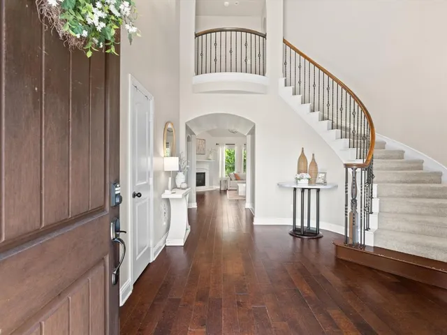 a view of front door with hallway and wooden floor