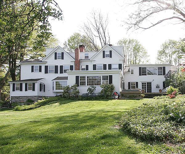 77 Kettle Creek Road Weston, CT 06883 - Photo 1 of 1 a front view of a house with a garden and trees