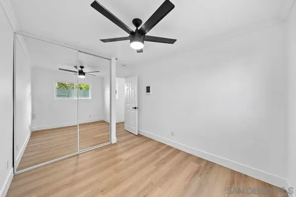 an empty room with closet and a ceiling fan