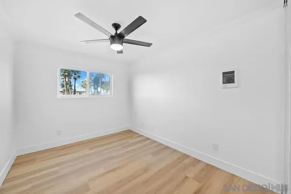 a view of a big room with wooden floor and ceiling fan