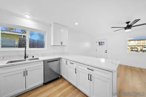 a kitchen with a sink cabinets and wooden floor
