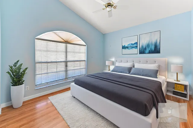 a bedroom with a large bed and a chandelier