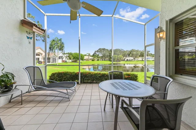 a view of a patio with a table chairs and a floor to ceiling window
