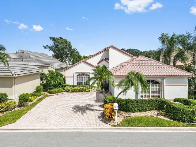 a front view of a house with a yard and potted plants