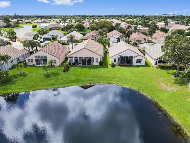 an aerial view of a house with a yard and lake view