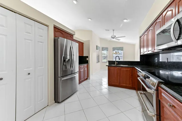 a kitchen with stainless steel appliances granite countertop a refrigerator and a sink