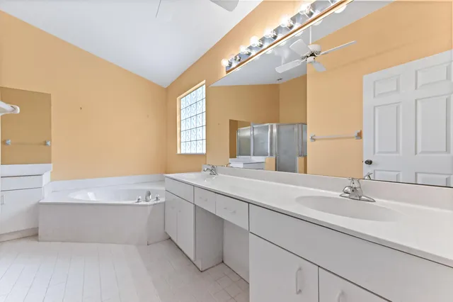 a bathroom with a tub sink and mirror