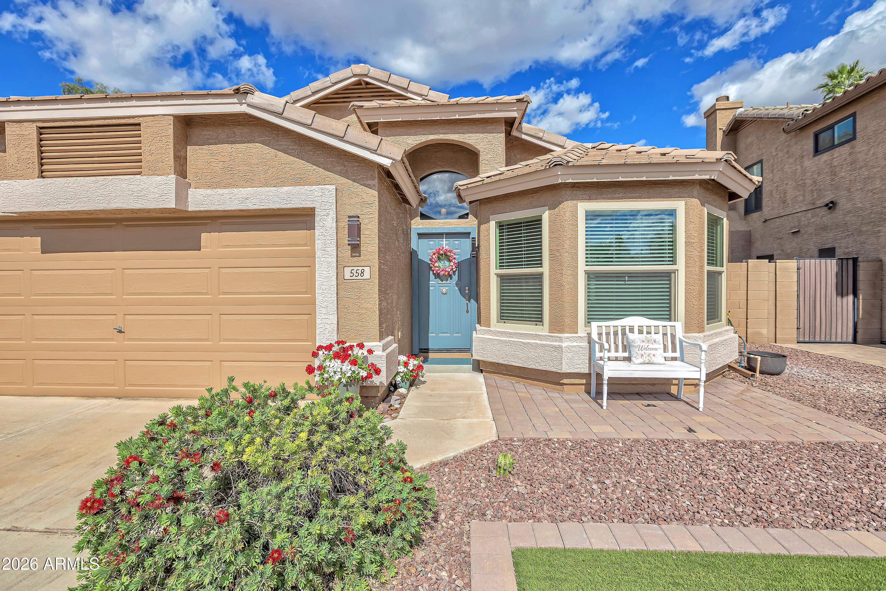 558 East Devon Drive Gilbert, AZ 85296 - Photo 2 of 42 a front view of a house with a garden and seating area