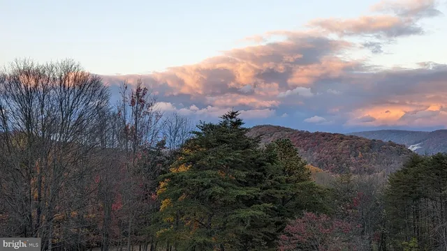 a living room with furniture a flat screen tv and a floor to ceiling window