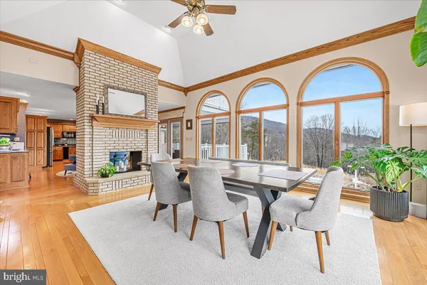 a dining room with furniture a fireplace and wooden floor