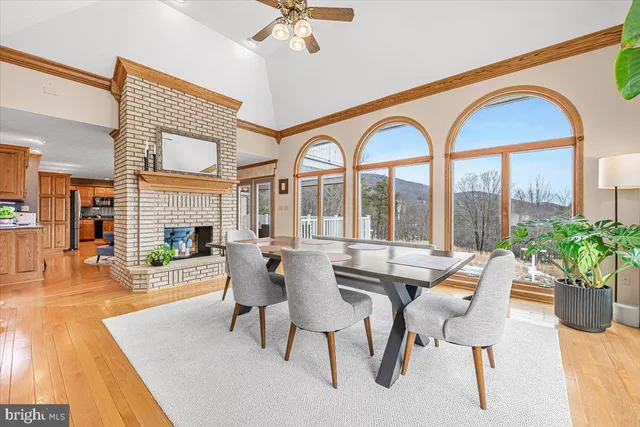 a dining room with furniture a fireplace and wooden floor