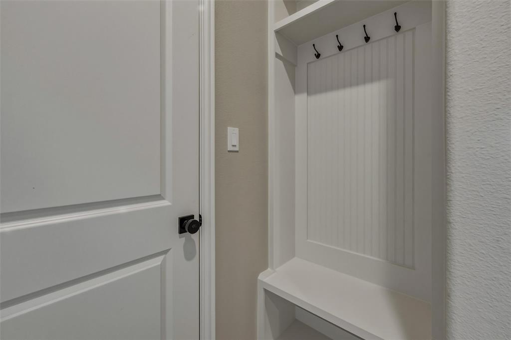 153 Big Sky Road Decatur, TX 76234 - Photo 7 of 38 Built-in storage unit with beadboard backing and black hooks, complemented by a white paneled door with a black knob