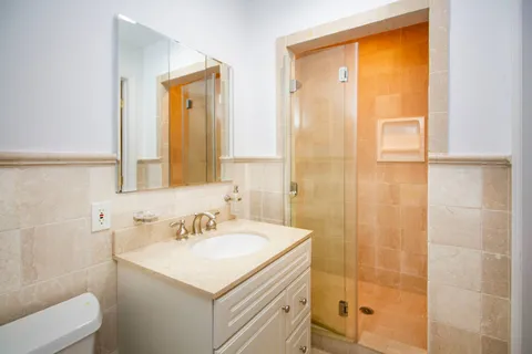 a bathroom with a sink a toilet and shower