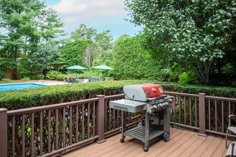 a view of a deck with furniture and trees around