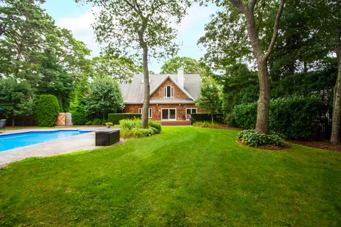 a view of a house with a yard patio and a small yard