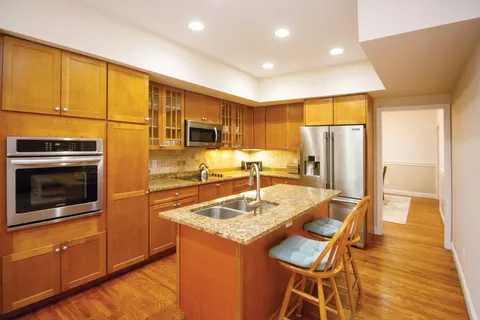 a kitchen with stainless steel appliances granite countertop a refrigerator and a stove top oven