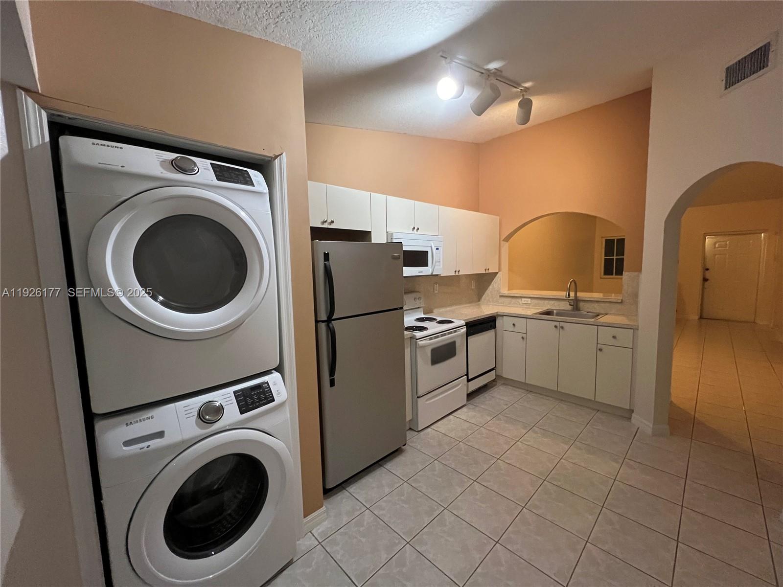 1251 Southeast 27th Street, Unit 204 Homestead, FL 33035 - Photo 2 of 11 a kitchen with a sink a washer and dryer