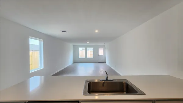a view of a big room with wooden floor and windows