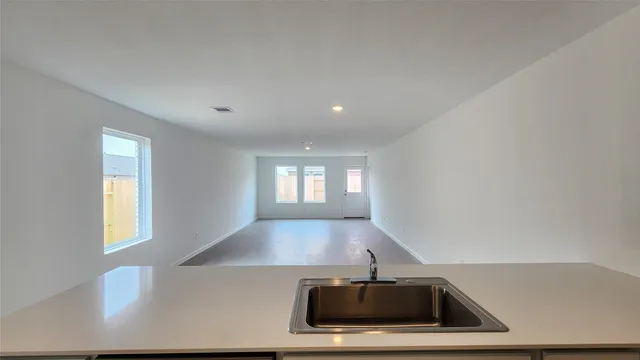 a view of a big room with wooden floor and windows