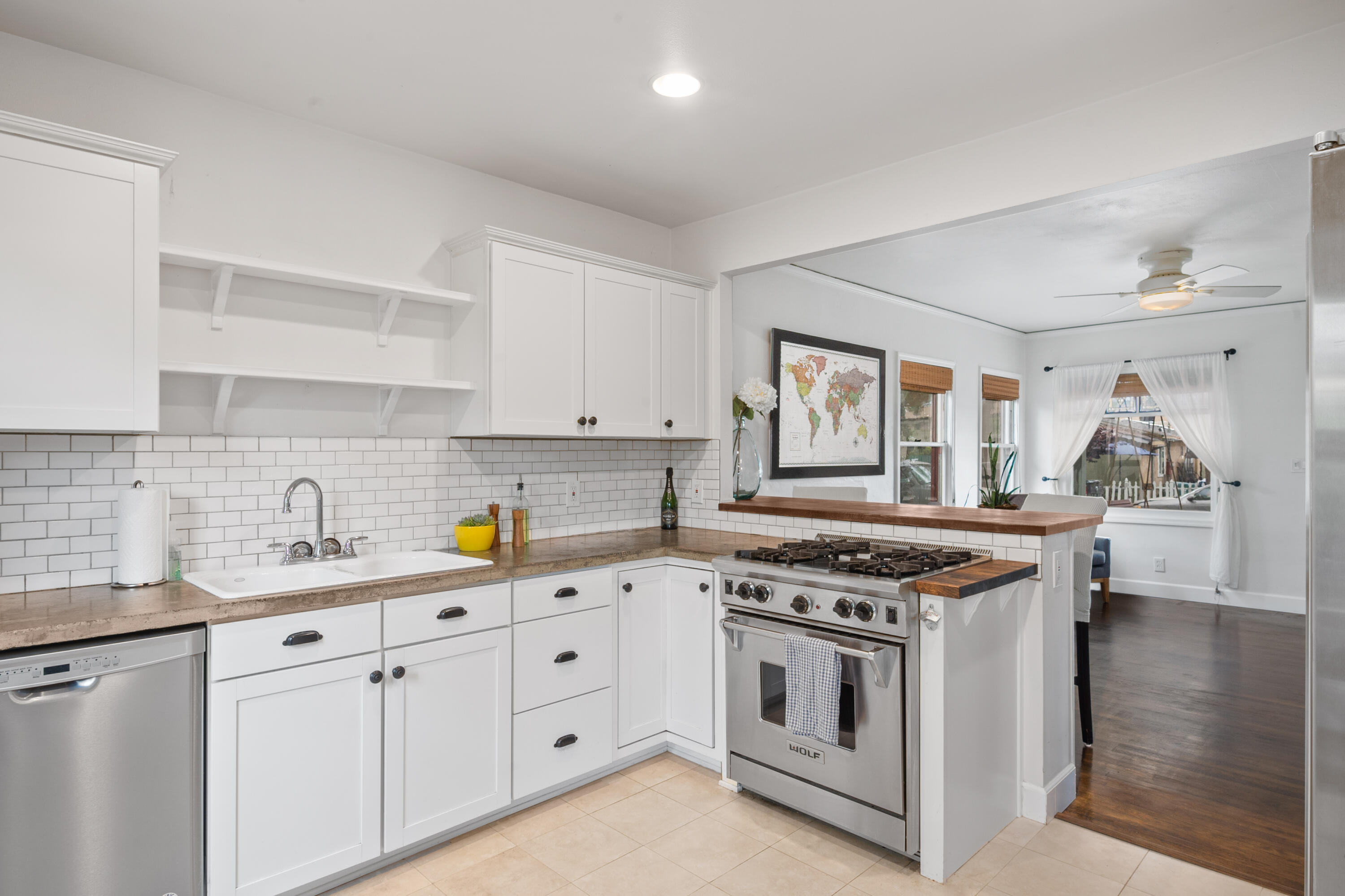 a kitchen with stainless steel appliances granite countertop white cabinets stove a sink and dishwasher