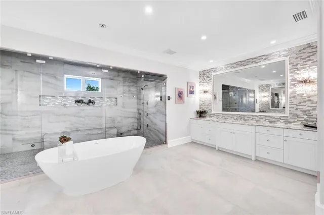 a spacious bathroom with a tub a sink and mirror