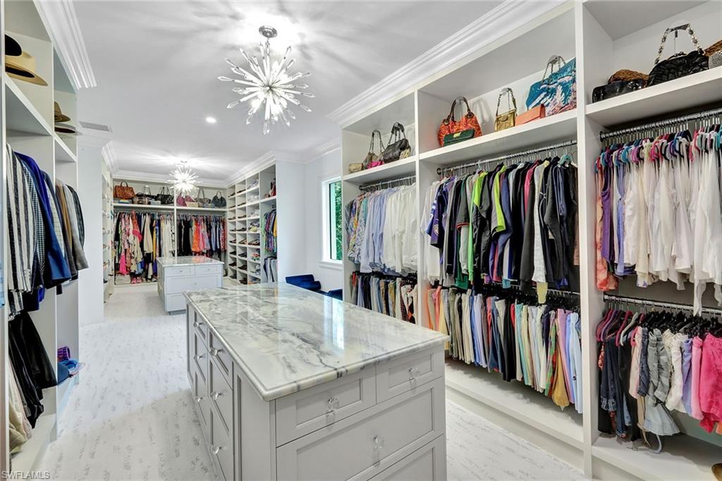 16770 Prato Way Naples, FL 34110 - Photo 15 of 29 a view of walk in closet with clothes and shoes