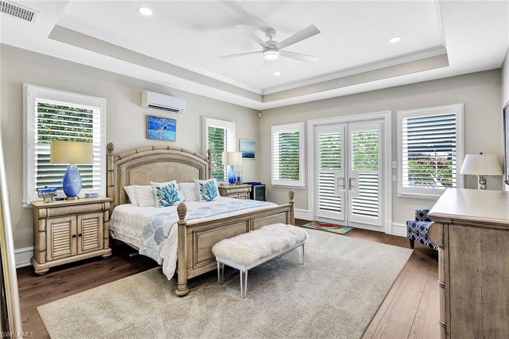 16770 Prato Way Naples, FL 34110 - Photo 16 of 29 a bedroom with a bed and a chandelier