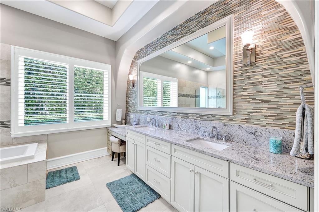 16770 Prato Way Naples, FL 34110 - Photo 17 of 29 a bathroom with double vanity and a large mirror