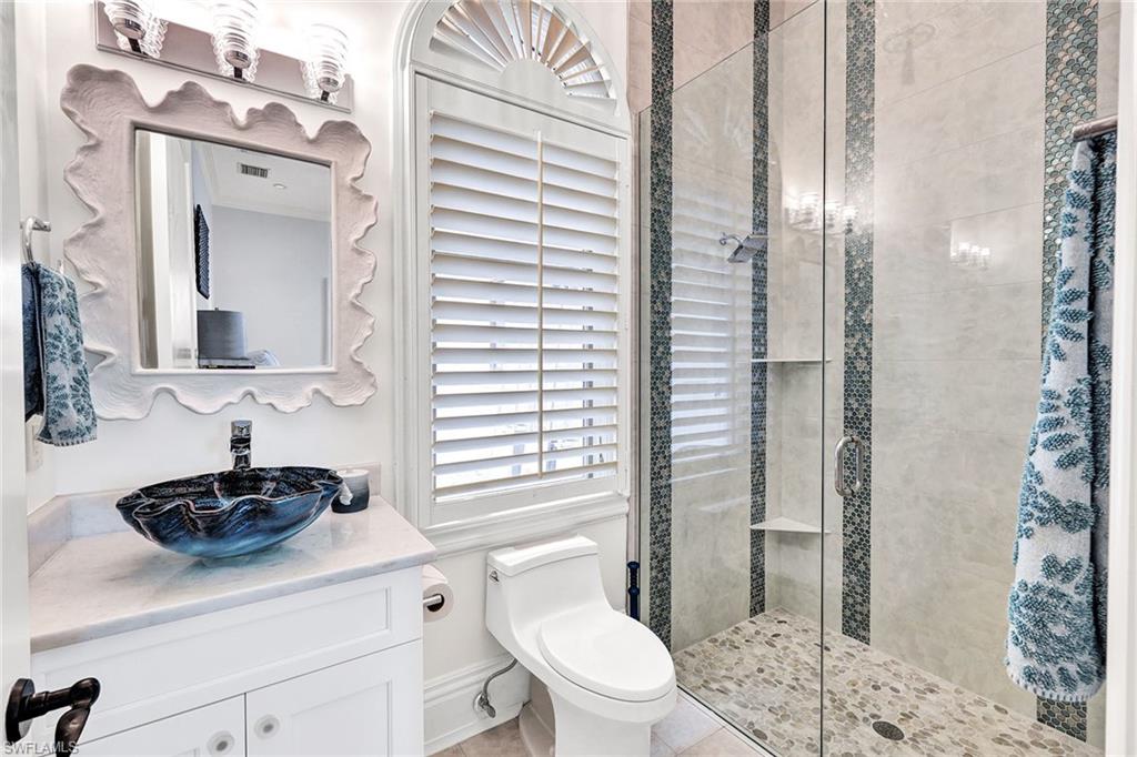 16770 Prato Way Naples, FL 34110 - Photo 20 of 29 a bathroom with a sink a toilet a mirror and shower