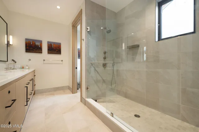 a bathroom with a bathtub shower sink and mirror