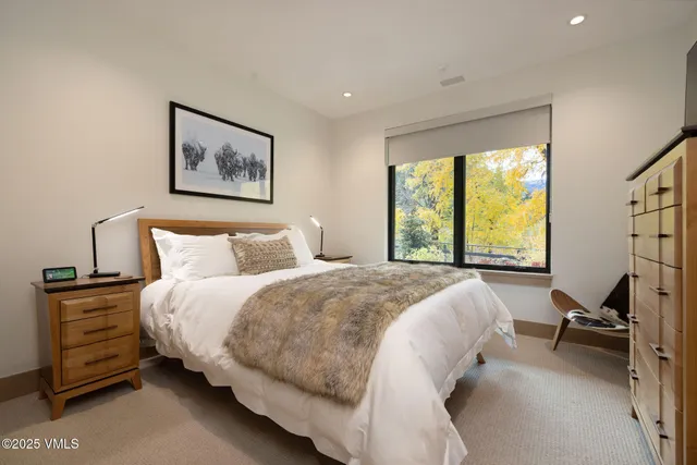 a bed sitting in a bedroom next to a window